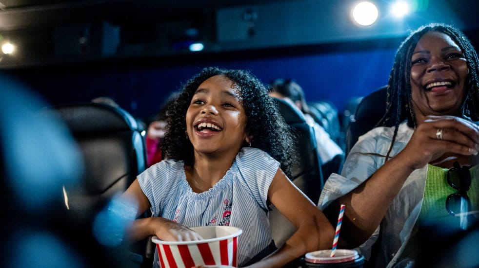 Woman and child at cinema eating popcorn